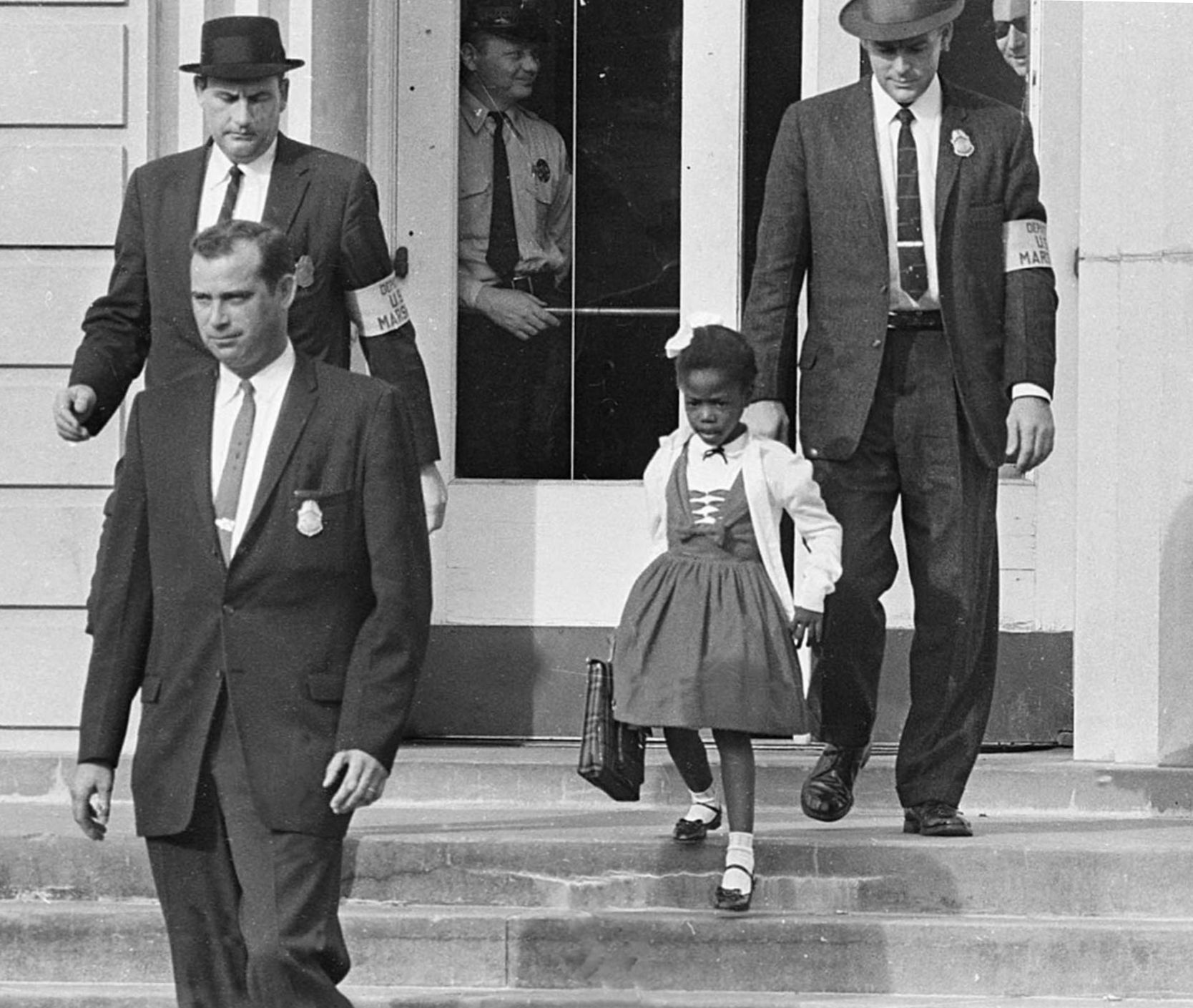 Federal marshals escort Ruby Bridges at the school.